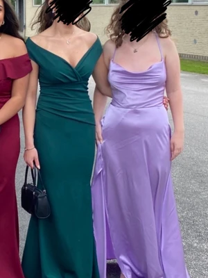 Grön långklänning från Goddiva - Elegant grön långklänning från Goddiva med v-ringad omlottdesign och smickrande drapering över byst och midja. Klänningen har offshoulder-ärmar och en slits på sidan för extra stilpoäng. Perfekt för bal eller festliga tillfällen.