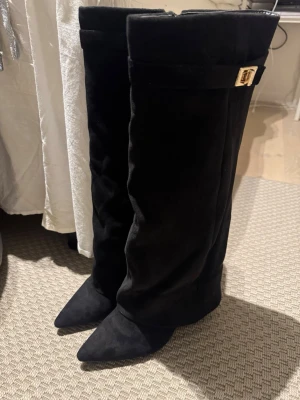 Svarta knähöga boots med gulddetalj - Snygga svarta boots i mycket fint skick. Endast använda en gång ute, inget slitage. Bekväma, stilrena och passar perfekt till både vardag och fest. Säljes pga kommer tyvärr inte till användning. Nypris 600 kr. ❗️pris går att diskutera vid snabb affär❗️