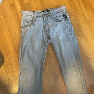 Ljusgrå jeans från Replay - Snygga ljusgrå jeans från Replay med klassisk femficksdesign och raka ben. Jeansen har tydliga sömmar och en diskret logga på bakfickan. Perfekta för dig som gillar en stilren och modern look. Superfint skick. 