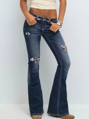 Mörkblå bootcut jeans med slitningar - Säljer ett par mörkblå lågmidjade bootcut jeans från Gina Young 14+, säljer då de inte kommer till användning längre💞