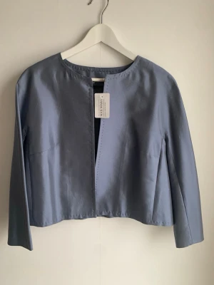 Blå kavaj från Max Mara S, XS - Stilren dimblå kavaj  med öppen framsida och rundad halsringning. Jackan har lång ärm och en croppad passform som ger en modern look. Perfekt att styla till olika outfits för en trendig vibe.