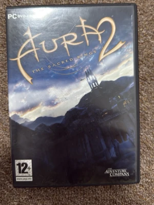 Hura 2: The Sacred Rings – PC, komplett med box + skiva + manual - Säljer Hura 2: The Sacred Rings till PC. Detta är en fullständig fysisk utgåva med: 	•	Originalbox (i mycket bra skick) 	•	Skiva några repor 	•	Manual  Spelet fungerar på äldre PC-system. 	•	Utgivet av The Adventure Company  Frakt: Mellanstorlek paket för att skydda boxen.  💰 Pris: 350 kr (eller högsta bud) 