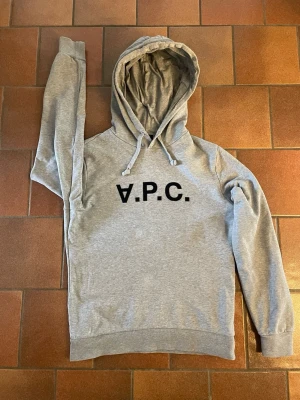 A.P.C hoodie storlek S - Grå A.P.C hoodie med uppochner vänt A i storlek S. Nypris ca 2800-3000 kr. Köpt på miinto