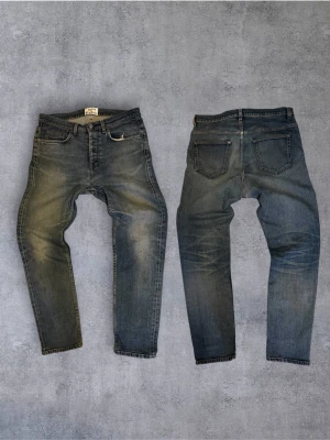 Sjukt feta Acne Jeans med sinnes tvätt - Säljer ett par blå acne med klassisk femficksmodell och snygga slitningar på framsidan. Jeansen har en något tvättad look och är tillverkade i bomull. Perfekta för en avslappnad och trendig stil. 31/32 har några defekter fråga gärna om de accepterar ingen retur!