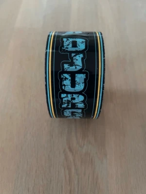 Svart tejprulle med blå text - Säljer en tejp rulle med texten ”DJURGÅRDEN” på. 