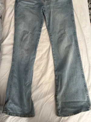 Ljusblå bootcut jeans - Ljusblå jeans med bootcut passform och klassisk femficksdesign från Gina tricot. Jeansen har en lätt tvättad look. Perfekta för dig som gillar en retrostil och vill ha ett par sköna jeans i garderoben. Som man ser på bilden är de smutsiga längst ner men såklart så tvättar jag innan jag skickar. Storlek 38.