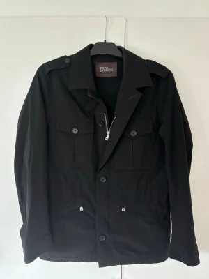 Oscar Jacobson archer jacket - Superfin snygg elegant och eftertraktad svart Oscar Jacobson jacka i storlek M säljes. Sjukt snygg grym passform och superfint skick! Perfekt nu till sommaren!