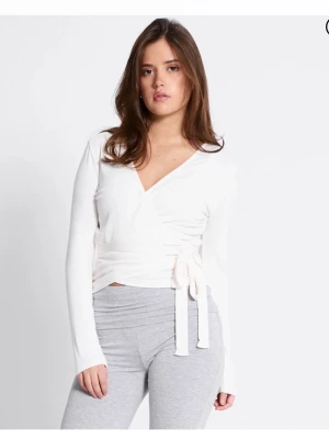 Vit omlottopp med knytband - Snygg vit omlottopp med långa ärmar och knytband i midjan. Toppen har v-ringning och är tillverkad i ett mjukt material som känns skönt mot huden. Perfekt att styla med jeans eller kjol för en trendig look.