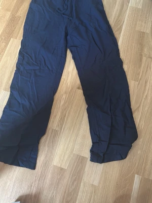 svarta linnebyxor med raka ben - Snygga svarta linnebyxor med avslappnad passform och raka ben. Byxorna har en enkel design utan synliga detaljer och är tillverkade i ett lätt och luftigt linnematerial. Perfekta för en chill och stilren look.