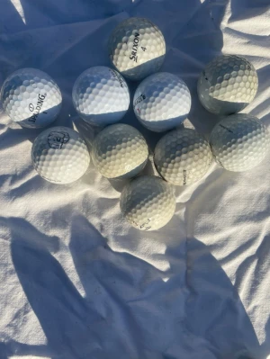 10 vita golfbollar blandade märken - Säljer ett set med 10 vita golfbollar från olika märken som Spalding, Srixon och Titleist. Perfekt för dig som vill fylla på golfbagen med extra bollar. Alla bollar är i klassisk rund form och tillverkade i slitstarkt material.