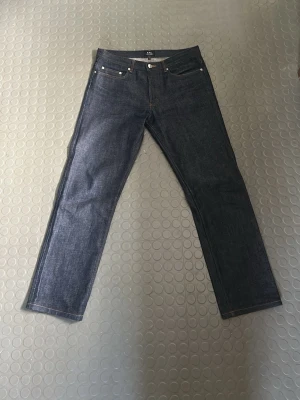 A.P.C. New Standard jeans mörkblå - Säljer ett par klassiska New Standard jeans från A.P.C. i mörkblå raw denim. Materialet är kraftig bomullsdenim med orangea sömmar. 