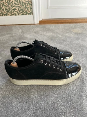 Lanvins DBB1 Cap Toe - Säljer ett par svarta Lanvins DBB1 Cap toe med glans i storlek UK8/43. Superbra skick och box samt dustbag medföljer! Hör av dig vid minsta lilla fundering!
