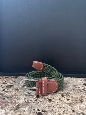 Grönt flätat bälte - Tja jag säljer ett mycket fint flätat skärp. Det är helt nytt och är ca 105-110cm och 3,5cm bret, men kan bli mycket längre pga det elastiska materialet. Det finns flera skärp i min profil om du skulle vara sugen och desto mer du köper desto billigare blir det.