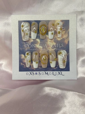 Lumina (S);Medium Ballerina - Unika handgjorda press-on naglar i vitt och nude med guldfärgade detaljer och guldpärlor. Designen har snäckmönster, stjärnor och skimrande effekter. Naglarna är handgjorda och har en elegant, lyxig känsla. Perfekt för dig som vill ha något extra till naglarna.S: 15 mm, 11,5 mm, 12 mm, 11 mm, 9 mm 