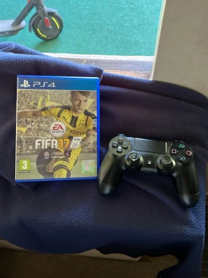 FIFA 17 till PS4 + svart handkontroll funkar på Playstation 5 - FIFA 17 till PlayStation 4 med original fodral och skiva. Spelet är ett fotbollsspel från EA Sports. Medföljer gör en svart DualShock 4 handkontroll. Perfekt för dig som gillar sportspel och vill spela med vänner på PS4.
