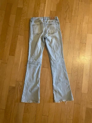 Ljusblå bootcut jeans Gina Tricot - Storlek 152. Säljer ett par ljusblå bootcut jeans från Gina Tricot. Jeansen har klassisk femficksmodell, råa kanter nertill och är tillverkade i denim med en snygg tvätt. Perfekta för dig som gillar en avslappnad men trendig stil. 