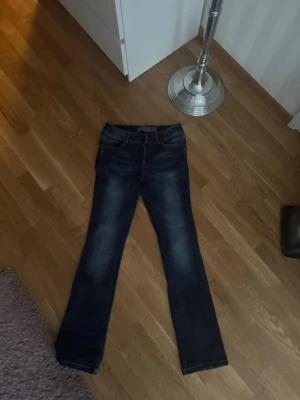 Mörkblå bootcut jeans - Säljer ett par mörkblå bootcut jeans med lätt slitningar framtill och klassiska bakfickor. Inga tydliga märken !
