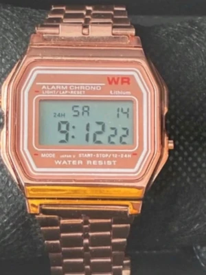 Digital roséguldklocka retrostil - Snygg digital klocka i roséguld med klassisk retrodesign. Klockan har rektangulär urtavla, digital display och länkarmband i metall. Funktioner som alarm, kronograf och vattentålighet. Perfekt accessoar för dig som gillar vintagevibbar.
