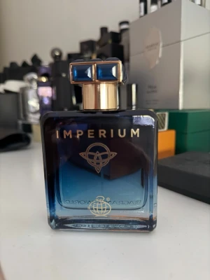 Fragrance world Imperium  - Snygg parfym från Imperium i en lyxig mörkblå glasflaska med gulddetaljer och en unik blå och guld kork. Endast provad så 99.9ml kvar. Luktar exakt som Roja elysium, super fräsch träig aromatisk parfym. 