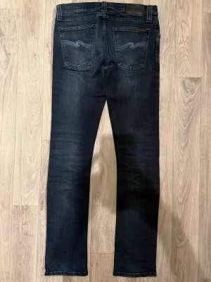 Nudie Jeans Mörkblå W29/L32 - Slim Fit - Nudie Tube Tom mörkblå jeans i organic denim med slim fit passform som sitter snyggt och bekvämt och funkar till allt, storlek W29/L32, midja 38,5 cm, ytterbenslängd 102 cm, benöppning 16 cm, modellen är 185cm & väger 65kg, i fint skick. Pris kan diskuteras. MVH stentorparchive⚓️