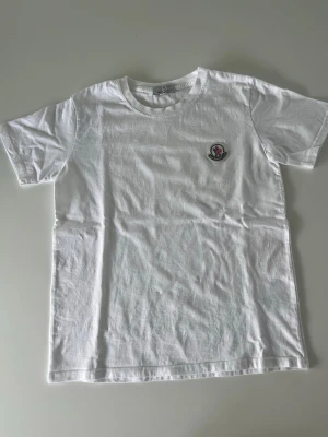 Moncler t-shirt  - Den är inte lika skrynklig som på bild, när den är struken eller ren är den precis som ny!  en klassisk vit t-shirt från Moncler med rund hals och korta ärmar. Köpt i Paris förra året