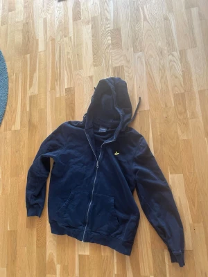 Lyle&Scott tröja - Snygg svart Lyle&Scott zip up. Använder den ej längre och har inte gjort på ett tag. Priset är inte hugget i sten.