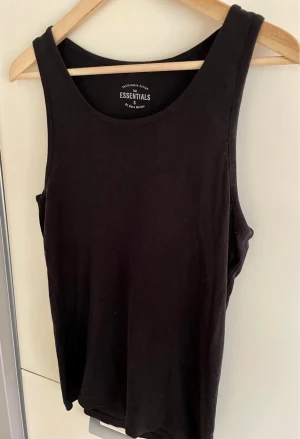 Svart linnetopp från Race Marine Essentials - Svart linnetopp från Race Marine, gjord i mjuk bomull. Klassisk rund halsringning och ärmlös design som ger en clean och enkel look. Perfekt att styla med jeans eller shorts för en chill vibe.