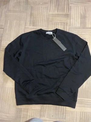 Svart sweatshirt från Peak Performance - En stilren svart sweatshirt från Peak Performance med rund halsringning och ribbade muddar vid ärmslut och nederkant. Tröjan har en klassisk passform och är tillverkad i mjukt material, perfekt för en avslappnad look.