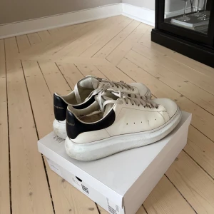 Alexander McQueen Sneakers - Säljer ett par Alexander McQueen Oversized Sneakers i storlek 44. Skorna är använda men fortfarande i bra skick.  Detaljer: Färg: Vit med svart hälkappa Material: Kalvläder med överdimensionerad gummisula Nya skosnören sitter i (originalsnören medföljer, men är lite skadade)  Köpta via Farfetch  Nypris ca 5 500 kr