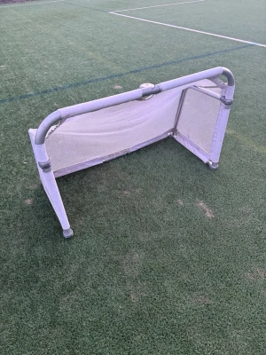 Hopfällbart vitt fotbollsmål - Smidigt hopfällbart fotbollsmål i vit metall och nät. Perfekt för spontana matcher på gräsmattan eller konstgräs. Målet är lätt att bära och förvara, och kan snabbt fällas ihop när det inte används. Passar både träning och lek.