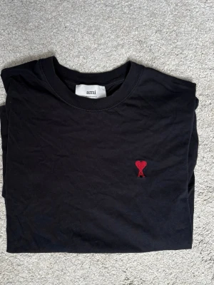 Ami Paris T Shirt - Säljer min svarta ami paris t shirt då jag inte använder den längre. Den är något använd men inget man märker eller har några flaws. Autentiskt brev från ami paris medkommer. Nypris runt 1500kr