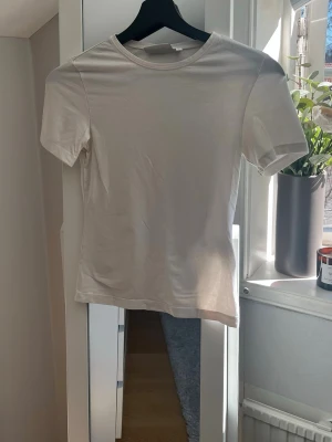 Vit basic t-shirt  - Vit tajt t-shirt från Weekday i fint skick. Säljer då den inte kommer till användning längre.