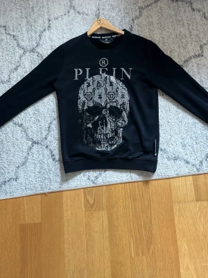 Philipp plein sweatshirt - Vanlig plein tröja.Original och har slutat tillverkas.bra skick, liten grön defekt på ryggen men knappt synlig. Samt lite slitningar nedtill (sista bild)  perfekt för dig runt ca 175-185.  Pris går att diskuteras🤗   /Mvh Max