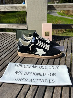 Golden Goose ballstar svart - Golden Goose sneakers i svart mocka med vit stjärndetalj på sidan och vita snören. Skon har beige sula och svart häl med broderad logga. Klassisk låg modell med retrovibbar och GGDB-märke på plösen. 0bs; lnte 0rglnal, men mycket bra kvalitet 😊
