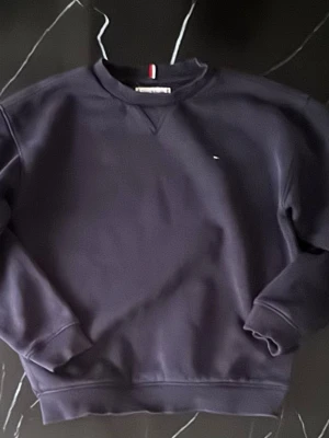 Tommy Hilfiger Navy Blue Sweatshirt – Size 140cm / Kids - Elevate your kid’s wardrobe with this classic Tommy Hilfiger sweatshirt! Color: Navy Blue Size: 140 cm (suitable for kids approx. 9-10 years old) Condition: Gently used, in excellent condition – no stains or tears Style: Iconic Tommy Hilfiger design, perfect for school, casual wear, or outings Material: Soft and comfortable cotton blend  Timeless, stylish, and perfect for layering. A must-have for any Tommy Hilfiger fan! Grab it now before it’s gone – classic  quality that lasts!