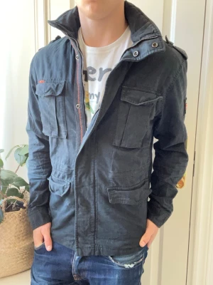 Superdry fieldjacket  - Superdry fieldjacket, stor på modellen, Inga defekter! Modellen i bilderna är 180 cm 75 kg och bär Storlek L , Kom med frågor! 🌟 (Kan gå ned i pris vid köp av paket 😉) 