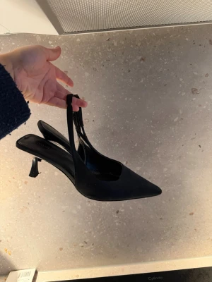 Svarta slingback pumps från nakd  - Stilrena svarta pumps från nakd  med spetsig tå och låg klack. Andvända 1 gång förra sommaren då de var för stora på mig. 