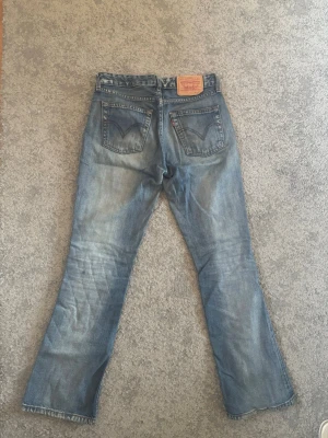 Levi's bootcut jeans i ljusblå denim - Säljer ett par low waist bootcut Levi's jeans. Jätte fint skick.  W: 27-28 L: 32🙌🏼🙌🏼 