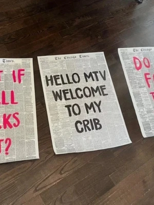 Poster med text  - Stor poster med tidningsbakgrund och svart text 'HELLO MTV WELCOME TO MY CRIB'. Bakgrunden liknar en gammal tidningssida från The Chicago Times. Perfekt som rolig väggdekoration till hemmet. Har två hål på varje från spikar och lite kladdig på baksidan från häftmassa 