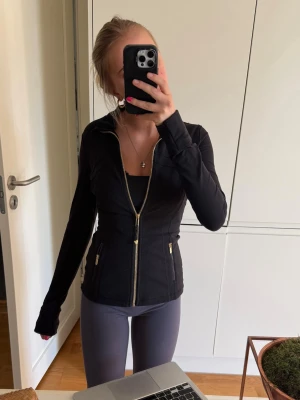 Svart Lululemon jacka med guldkedja - Svart lululemonjacka i jätte bra skick. Storlek 4. Skriv för frågor💓