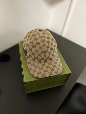 Gucci keps - Hej, Jag säljer min Gucci keps som jag inte funnit någon användning för. Kepsen är i Nyskick, storlek S (57 cm) Box och dustbag medföljer✅ Självklart Äkta✅