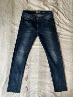 Mörkblå jeans från dressmann - Snygga mörkblå jeans från dressmann. Klassisk femficksmodell med dragkedjegylf och knapp. Jeansen har en modern passform och är perfekta för en trendig vardagslook. Skriv om du har några funderingar😁