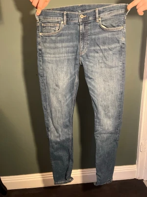 Ljusblå slim fit  jeans med fem fickor - Säljer ett par ljusblå skinny jeans med klassisk femficksdesign och dragkedjegylf. Jeansen har en snygg tvätt och smal passform som sitter tight hela vägen ner. Perfekta för en avslappnad och trendig look.