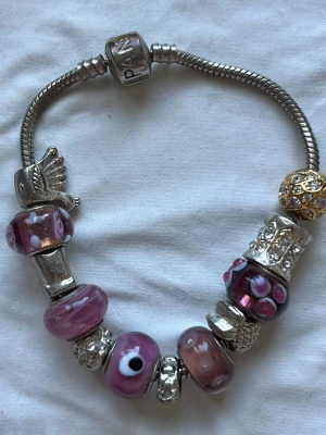 Armband med ormlänkspärlor - Inte äkta Pandora. 20 cm långt.Missfärgningar på flera ställen! 