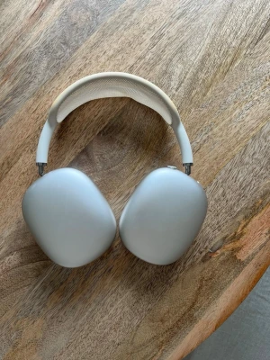 Apple AirPods Max silver hörlurar - Snygga over-ear hörlurar från Apple i silver med mjuka öronkuddar i mesh och aluminiumkåpor. Bygeln är vadderad och täckt med vitt meshmaterial för extra komfort. Perfekta för musik, gaming eller film.