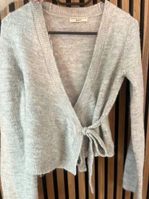 Ljudgrå kofta  - Mysig ljusgrå omlottkofta från gina tricot med knytband i midjan och djup V-ringning.💕