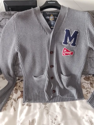 Grå ribbstickad kofta från Morris - Grå ribbstickad kofta från Morris med knappar framtill. Koftan är en lite bredare modell, passar bra till sommar'n och är väldigt bekväm. 