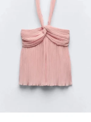 Ljusrosa plisserad halterneck topp från Zara  - Supersöt ljusrosa halterneck topp med plisserat tyg och twistad detalj framtill. Toppen är ärmlös och har en flowy passform, perfekt för varma dagar. Materialet känns lätt och luftigt. Passar storlek S/M