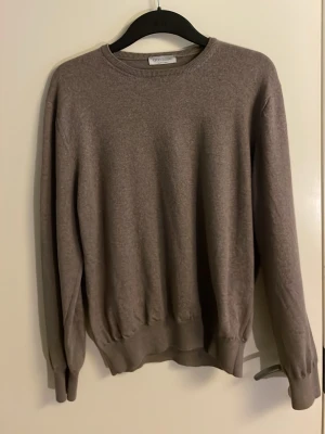 Beige stickad tröja Gran Sasso - Säljer en stilren beige stickad tröja från Gran Sasso. Tröjan har rund halsringning, långa ärmar och ribbade muddar vid ärmslut och nederkant. Tillverkad i Italien och passar perfekt för lager-på-lager-stil.
