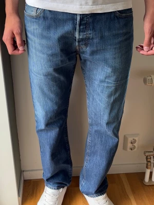 Levis 501 Jeans Vintage - Levis 501, raka jeans. Färg: Blå | Modell: 501 | Storlek: W34 L32 |.  Killen på bilden har fått dragit ner byxorna en del i syfte att visa passform, kolla måtten nedan för att se om dem passar! Mycket gott skick, inga skador eller slitningar.   Mått: Midja: 43 cm Längd: 102 cm Beslut: 20,5 cm Lår från grenen: 29 cm  Tveka inte att höra av dig minsta fråga eller fundering!  Skickas snabbt!